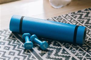 Yoga mat and weights lay by a window